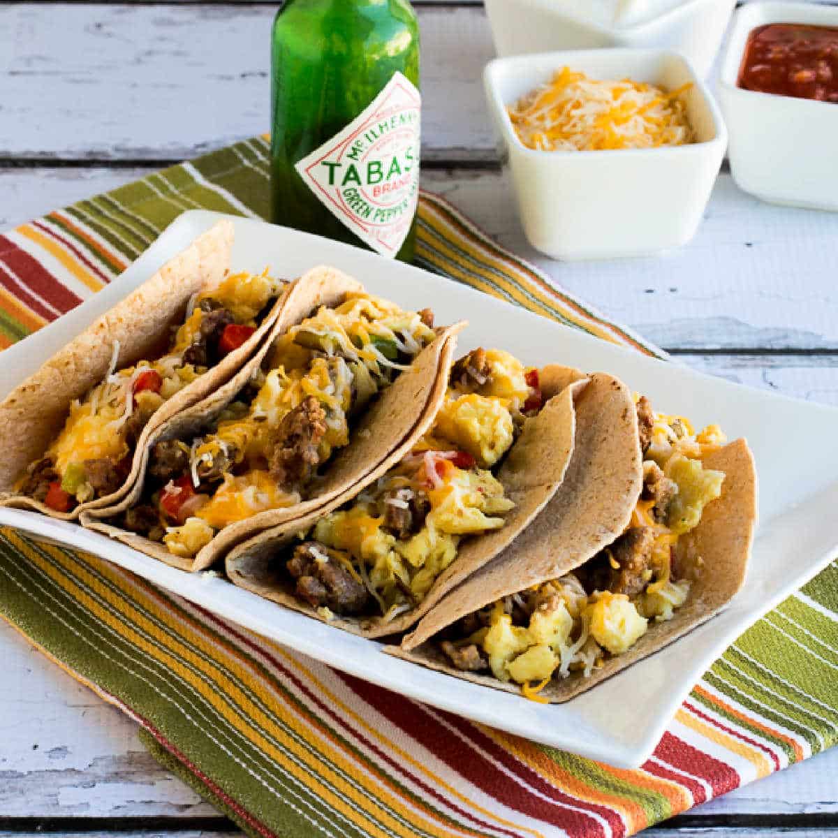 Breakfast Tacos with eggs, sausage, peppers, and cheese shown on serving platter.