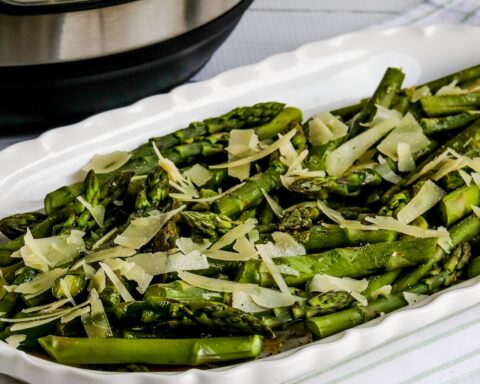 Square image for Instant Pot Asparagus on platter with Parmesan and Browned Butter and Instant Pot in back.